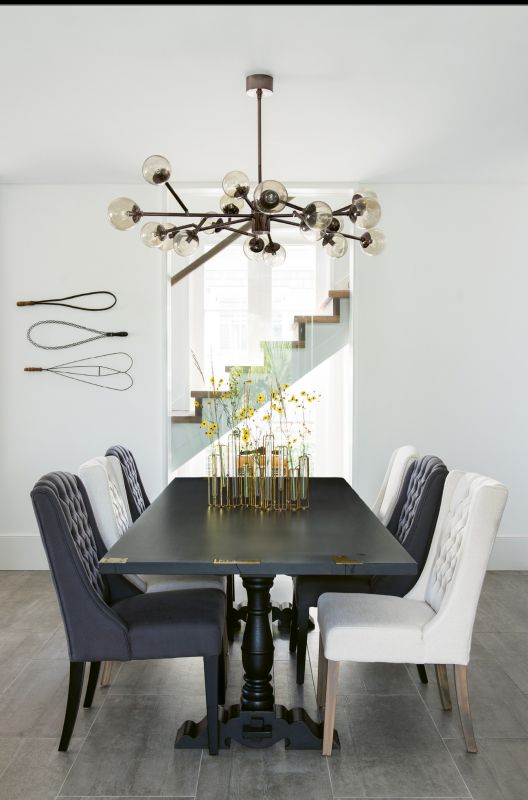 The couple commissioned cabinetmaker William C. Pritchard to produce a wooden table similar to one they had admired in the Hudson Valley. The upholstered chairs are from ABC Carpet & Home, the mid-century-inspired “Dallas” chandelier from Arteriors.