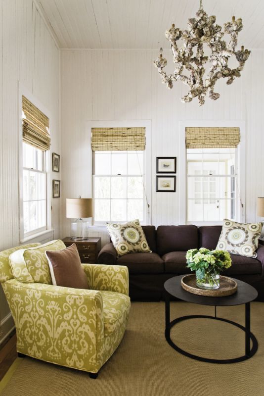 room service: A petite sitting room just inside the front door functions as a den. The sofa was re-covered with a no-fuss chocolate-hued slipcover, the table is from GDC, and the oyster shell chandelier was reused from Jenny’s old house.