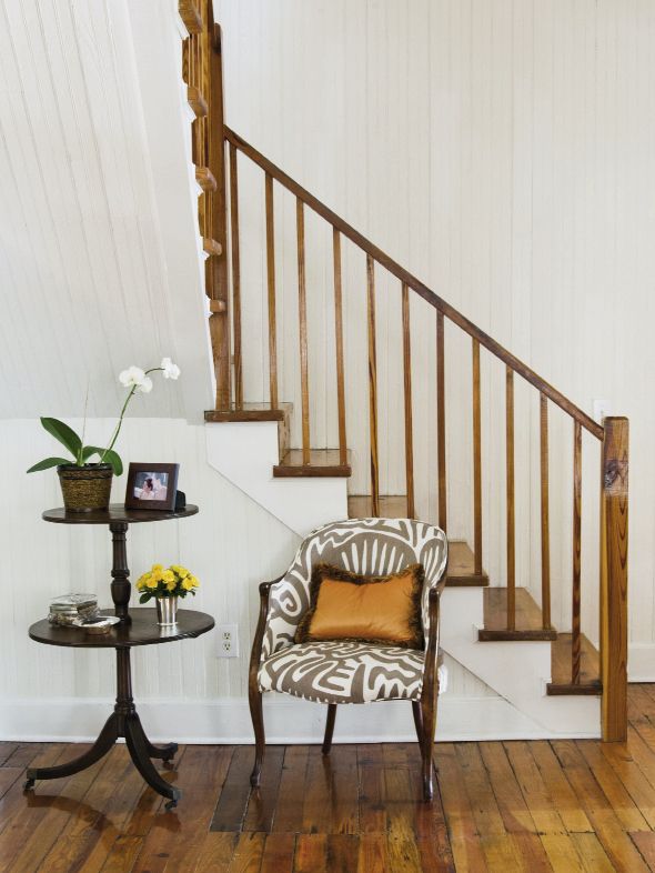 A mahogany pedestal table paired with a patterned armchair.