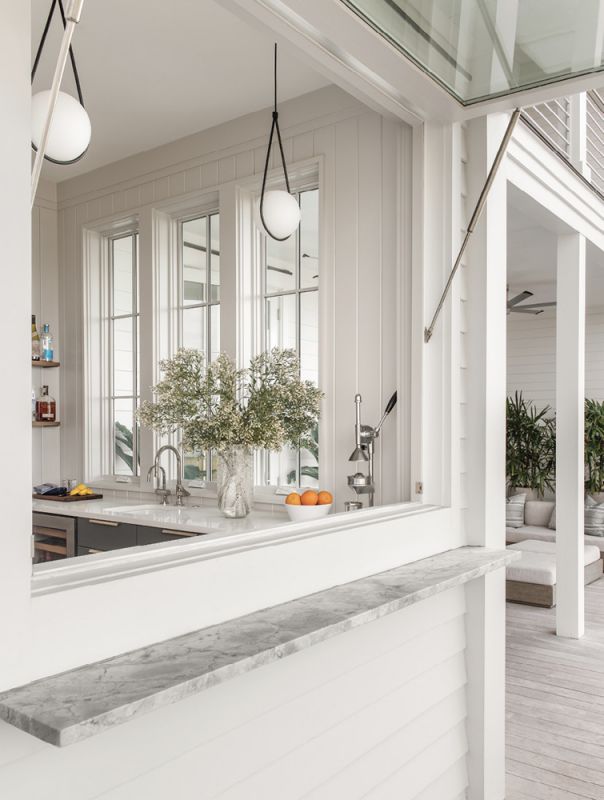 The doors to the left lead to an indoor/outdoor bar area, where a large window opens to the deck.